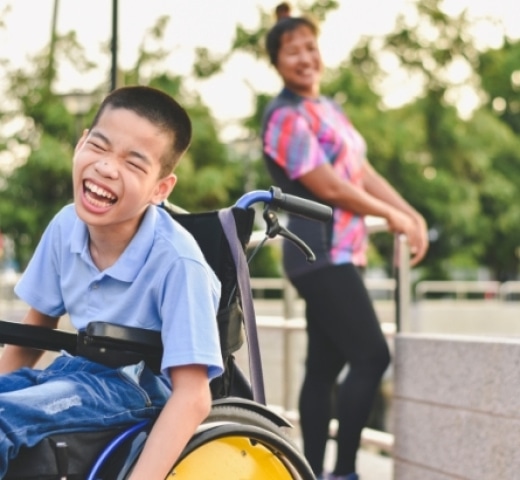 child in wheelchair laughing